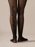 Back view close-up of the legs in the Back Vine Sheer Tights in Black, showing the vine pattern running up the back.