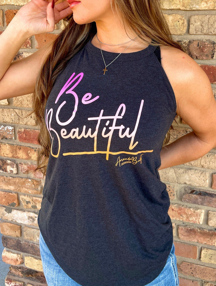 Amanda Bright Designs female model wearing a dark gray tank top with the text 'BE BEAUTIFUL' and a signature tagline printed in sunset colors.