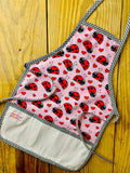 Amanda Bright Designs Children's ladybug hearts apron pink with red and black ladybugs and black checkered trim