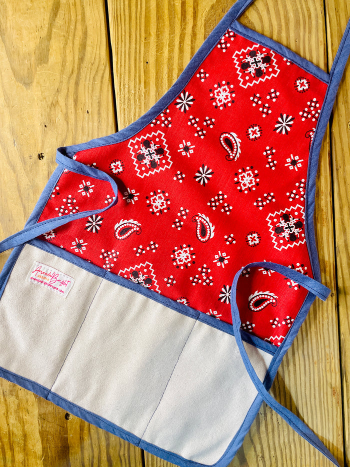 Amanda Bright Designs Red bandana-patterned children’s apron with denim blue trim and strings