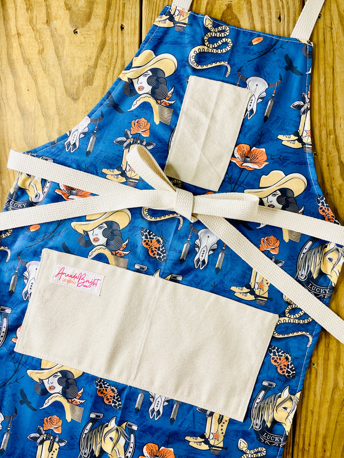 Blue apron with cowgirl pattern Amanda bright designs rattlesnake horse head, Rose cowboy boots western