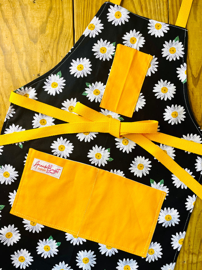 Amanda Bright Designs black apron with white daisy pattern apron with gold strings and pockets