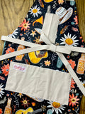 Amanda Bright Designs Desert Cowgirl Apron with colorful western guitar cactus cowboy hat sunflower pattern on black background