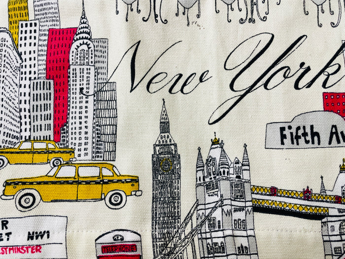 Amanda Bright Designs Evelyn Apron Illustrated fabric with New York-themed design featuring a taxi, Big Ben, and Fifth Avenue.
