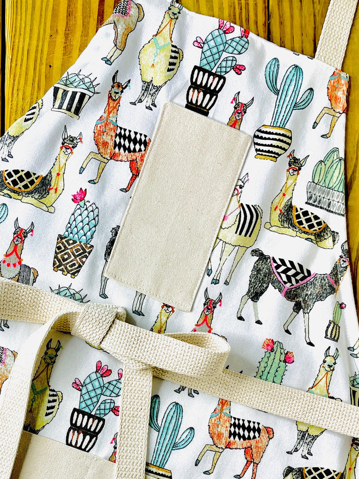 Amanda bright designs multicolor llama apron cutaway showing llamas with decorative saddles southwest cactus flowers in herringbone and harlequin pattern pots