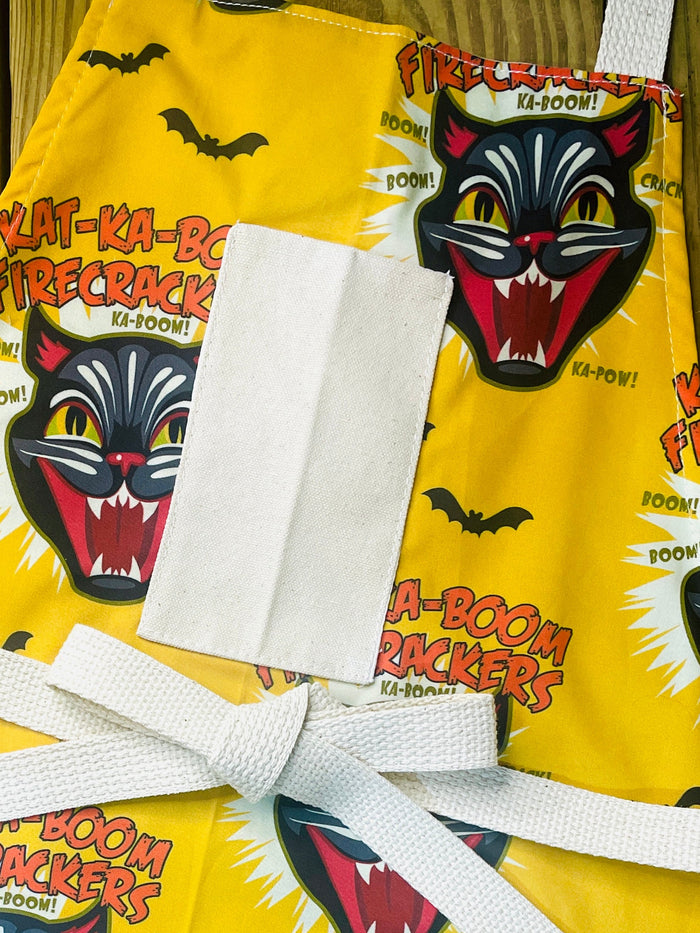 Amanda Bright Designs Ka-Boom Black Cat Fireworks Yellow and Black Bats Halloween theme Apron
