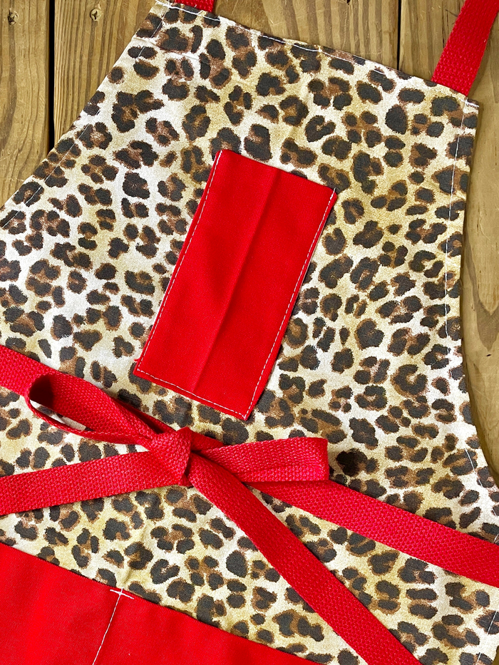 Leopard print apron with red pockets and red strings by amanda bright designs