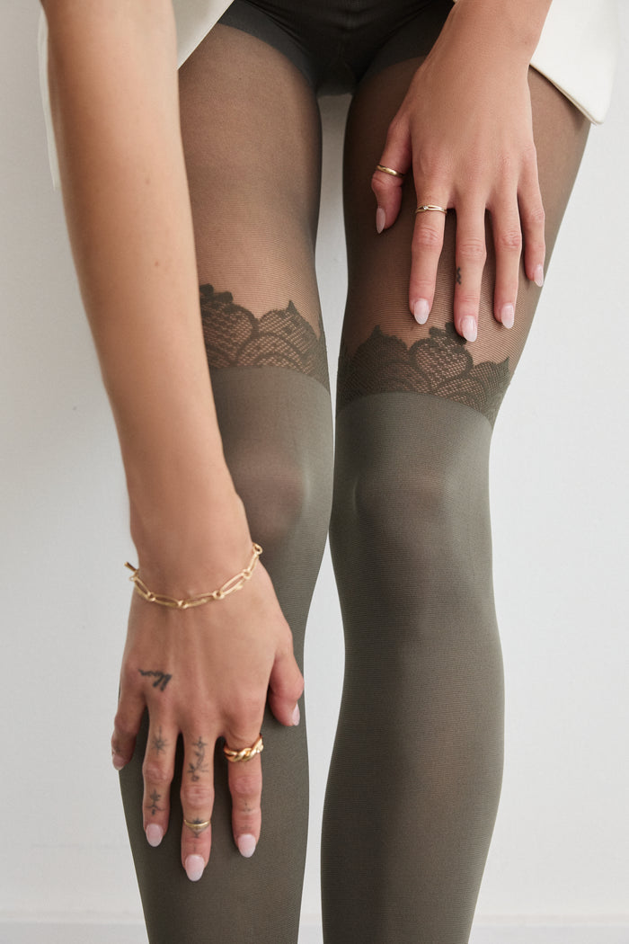 Close-up of Rachel's Lace Crown Over-the-Knee Tights in Olive, showing the lace pattern at the top of the thigh.