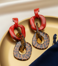 Amanda Bright Designs Red and leopard print tortoiseshell earrings on a gold tray