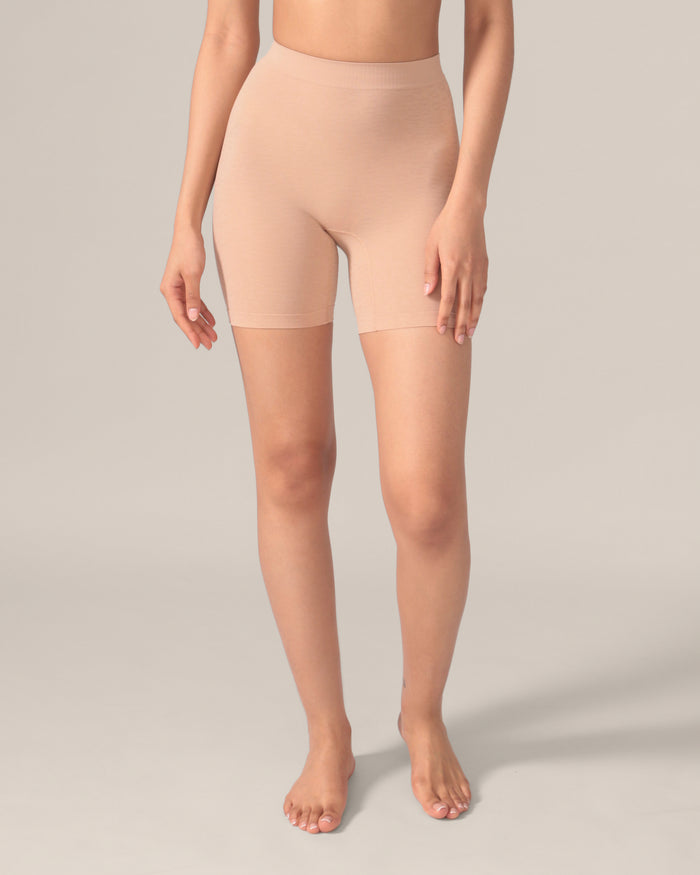 A pair of beige seamless undershorts with a subtle leopard pattern, high-waisted with a 6-inch inseam, displayed on a model.