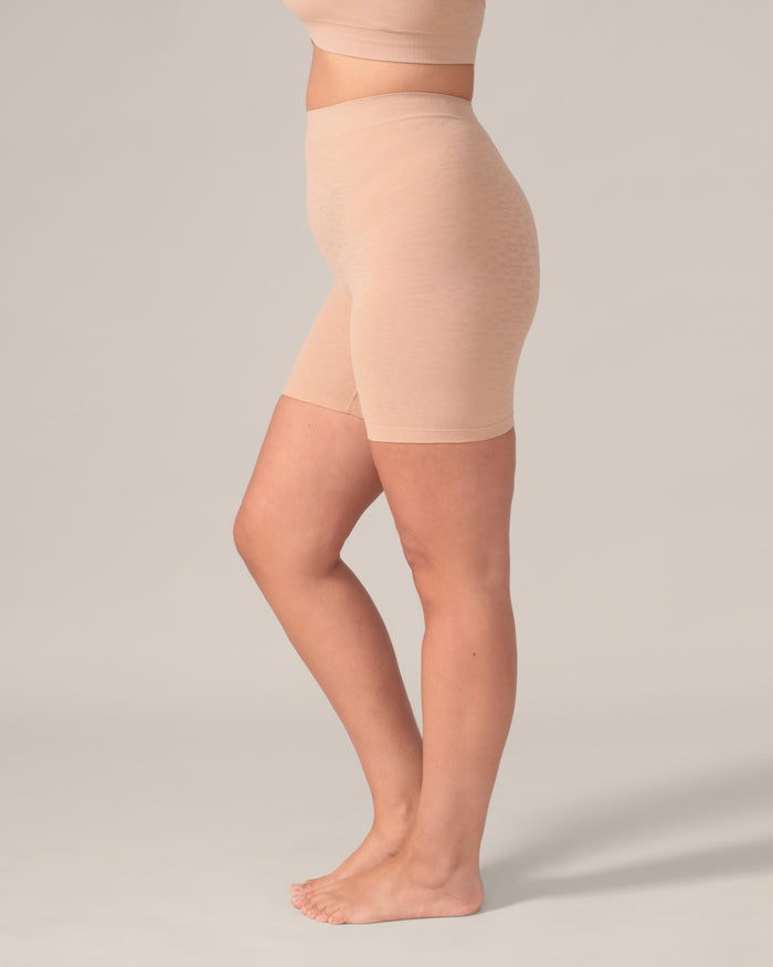 Beige shapewear garment on a model against a plain background