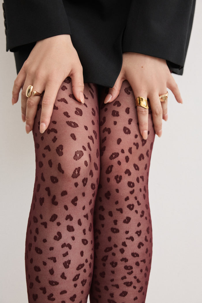 Close-up of Rachel's Mini Leopard Tights in Zinfandel, showing the leopard print detail from thigh to knee.