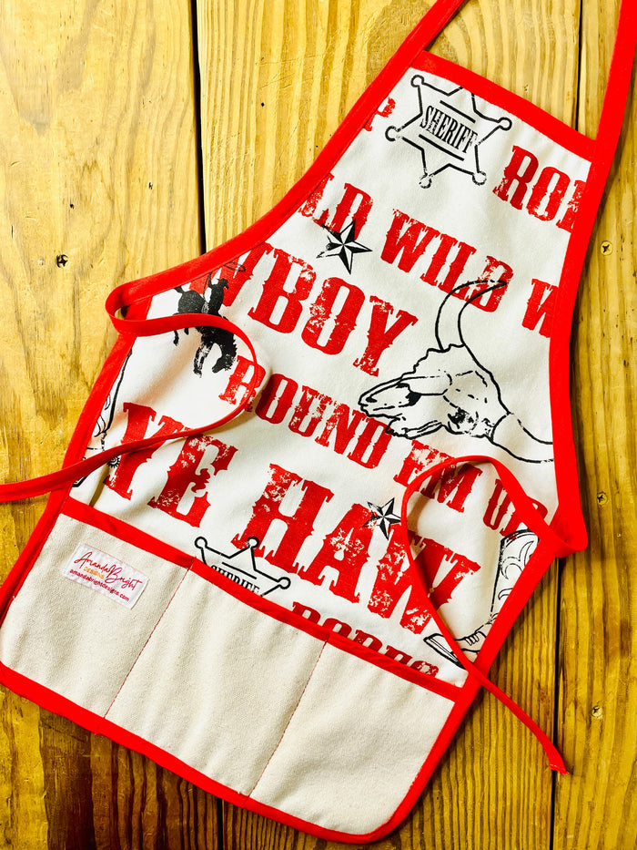 Amanda Bright Designs Jane Apron Children's Cowboy Print Giddy Wild West Horse Spurs Boots with Red Apron Strings and Three Pockets