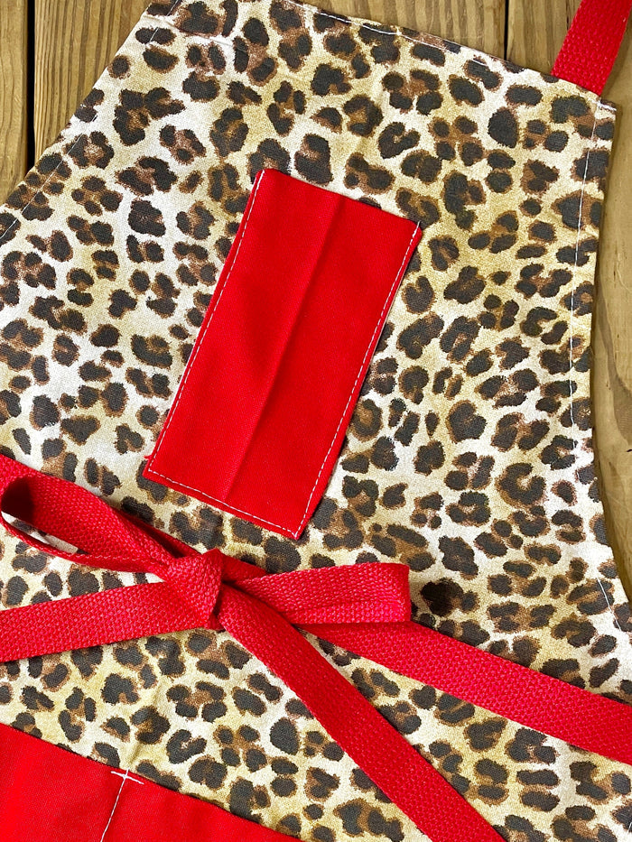 Amanda Bright Designs Leopard print apron cutaway with red pockets red strings and high fashion design