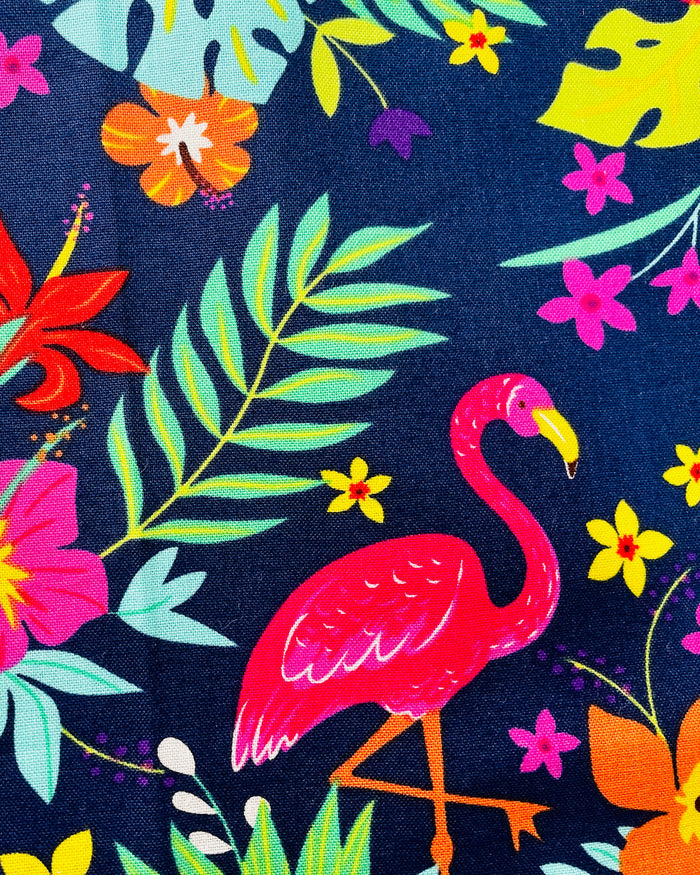 Amanda Bright Designs Nikki multicolored tropical Florida Hawaii floral apron with pink flamingo patterns on a blue background, featuring cotton strings and canvas pockets