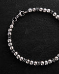 Silver beaded bracelet on a black background