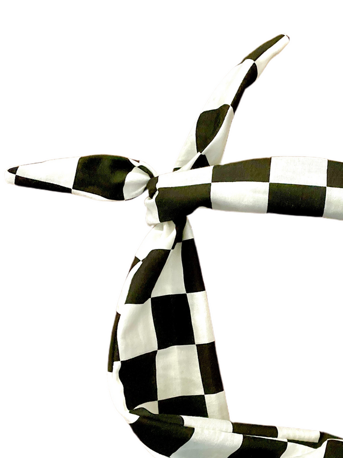 A black and white checkered headband tied in a knot amanda bright designs moldable bendable original tie headband