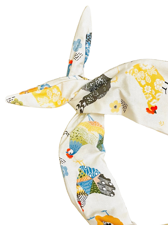 Amanda bright designs farmhouse style cream-colored fabric headband with a colorful, whimsical print of chickens and flowers