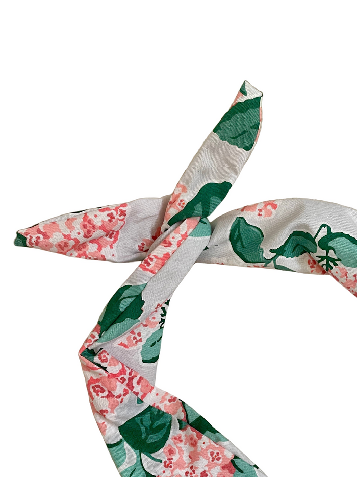 Amanda Bright Designs pink hydrangea floral headband with a floral and leaf pattern in green, pink, and white, styled in a loose knot