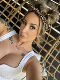 Woman wearing a leopard print headband and white top against a woven background Amanda Bright Designs